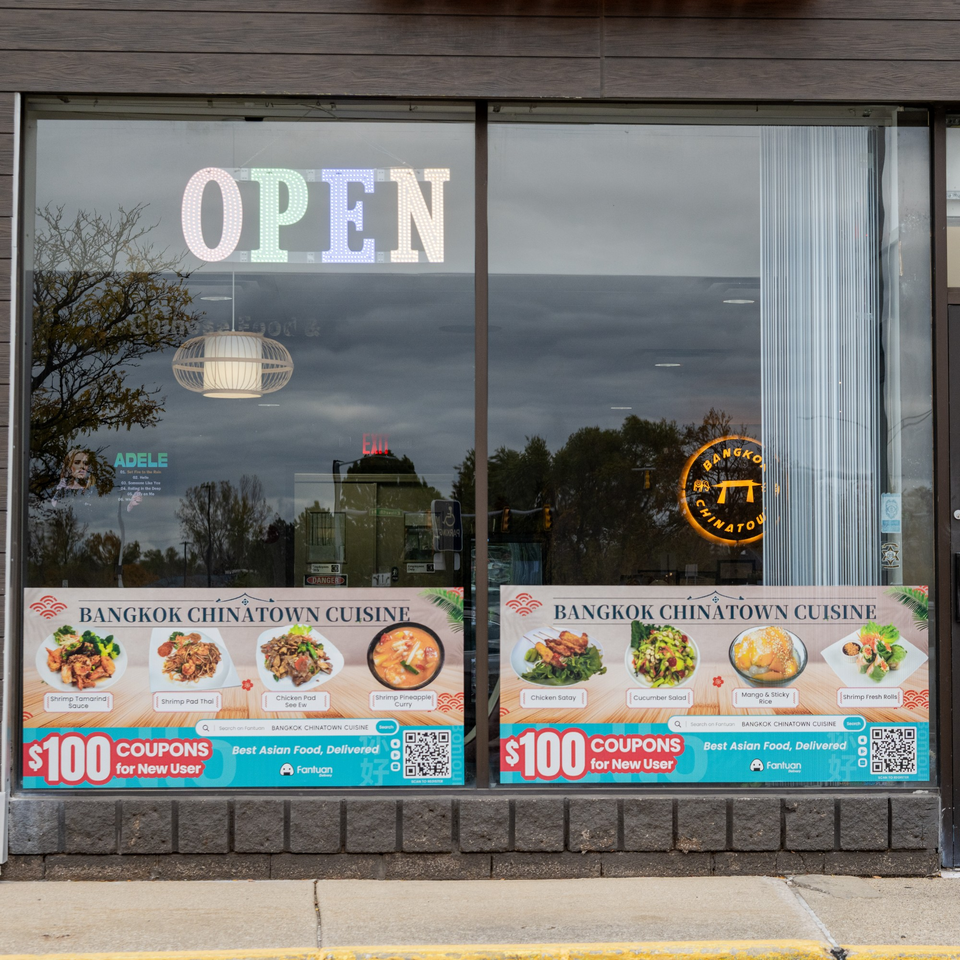 The exterior of Bangkok Chinatown Cuisine, featuring an "OPEN" sign and promotional banners with Thai dishes.
